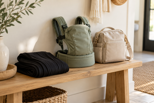 Folded black baby wrap and sage buckle carrier on a bench; illustrative comparison.
